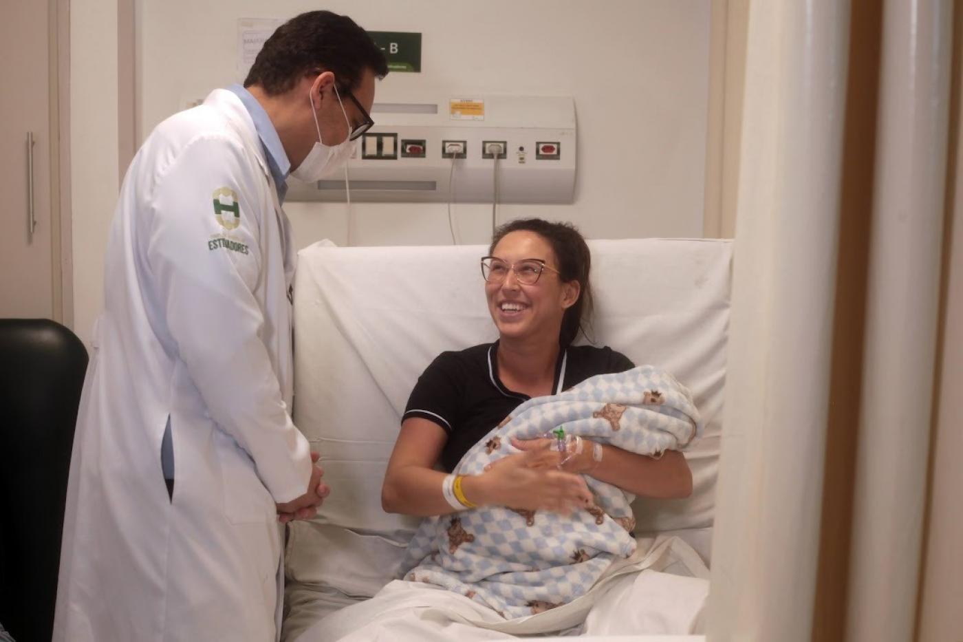 mãe com bebê no colo fala com médico #paratodosverem