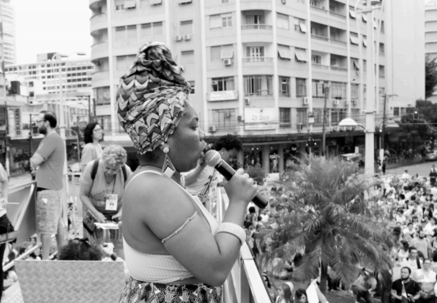 mulher fala ao microfone em comício #paratodosverem