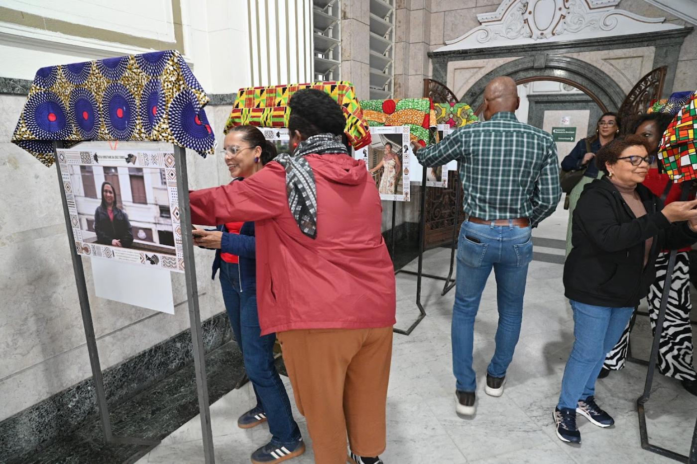 pessoas olhando as fotos #paratodosverem