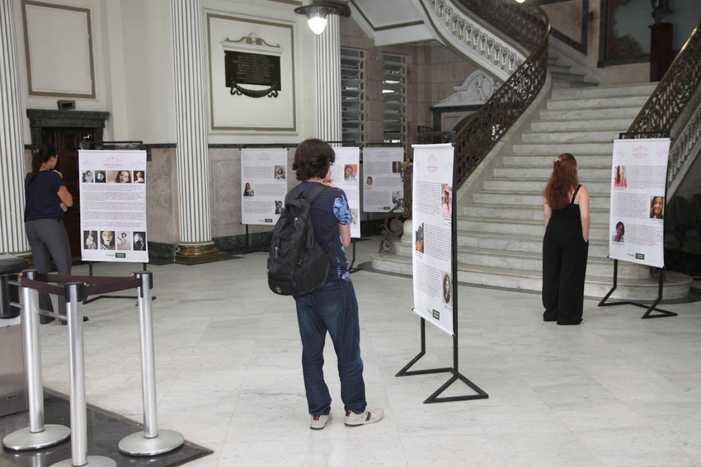 pessoas olhando a exposição #paratodosverem 