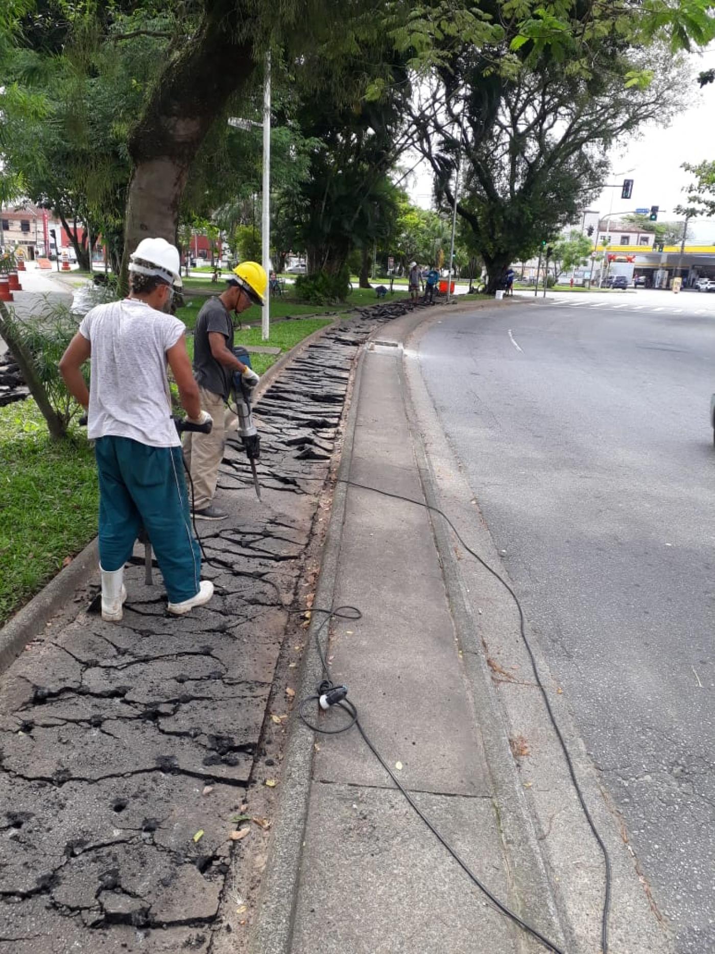 dois homens quebram asfalto de ciclovia com britadeira. #paratodosverem