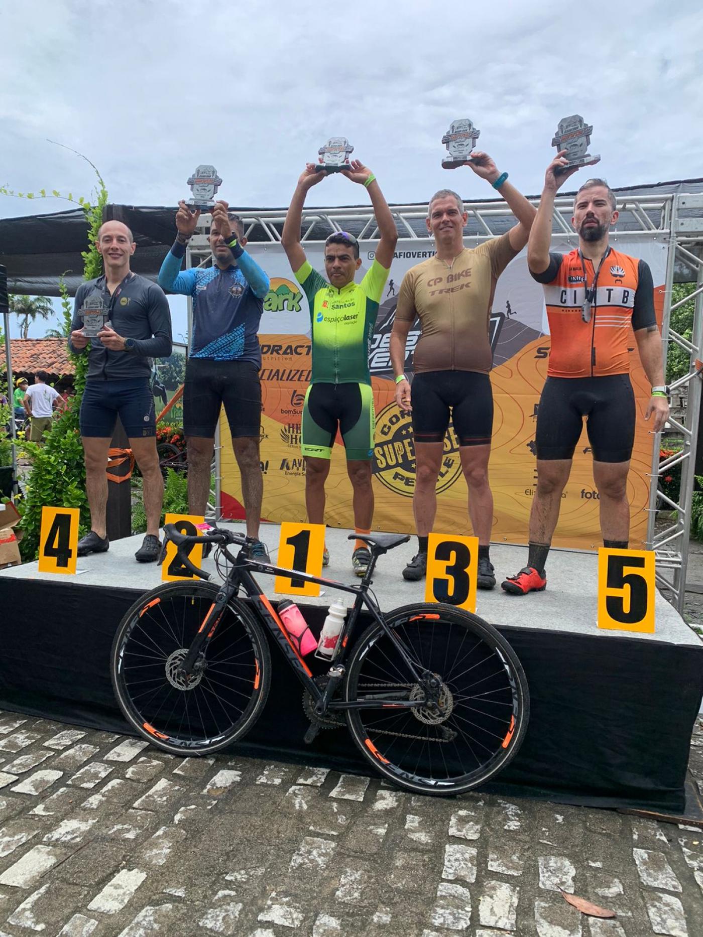 gilberto sousa posa para foto segurando troféu no primeiro lugar do pódio. #paratodosverem