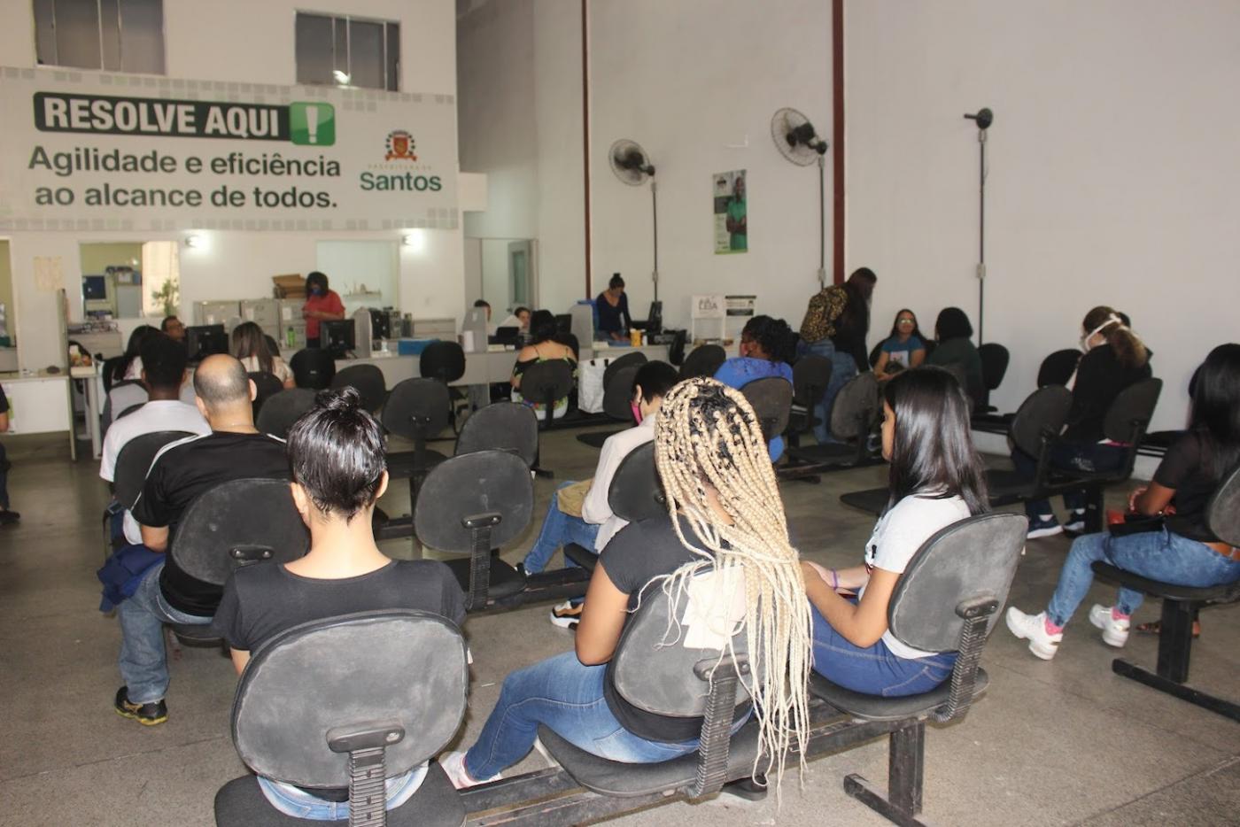 mulheres e homens estão sentados aguardando atendimento no Centro de Emprego. #paratodosverem