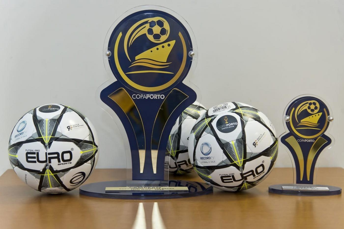 bolas e troféu sobre uma mesa. #paratodosverem