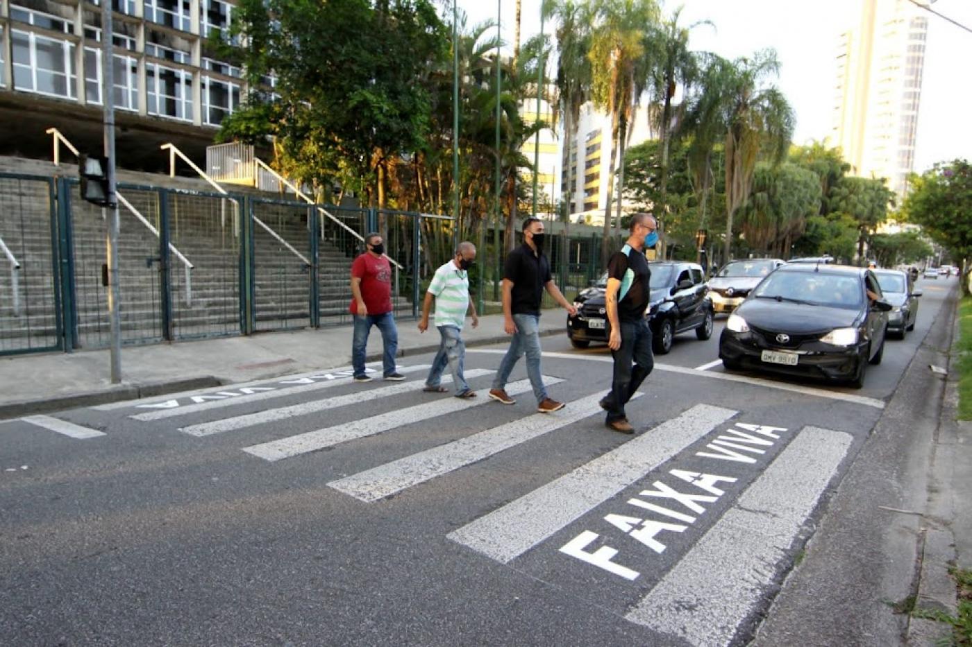 quatro homens atravessam faixa de pedestre com a inscrição faixa viva. #paratodosverem