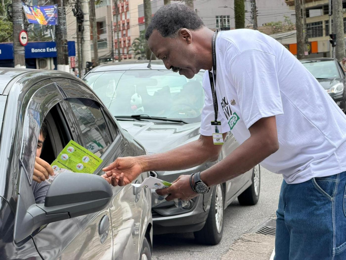 agente entrega panfleto a motorista #paratodosverem 