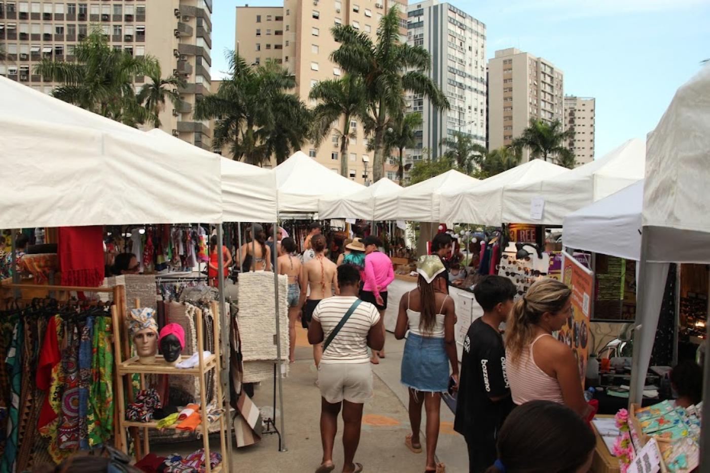 pessoas olhando produtos em feira #paratodosverem