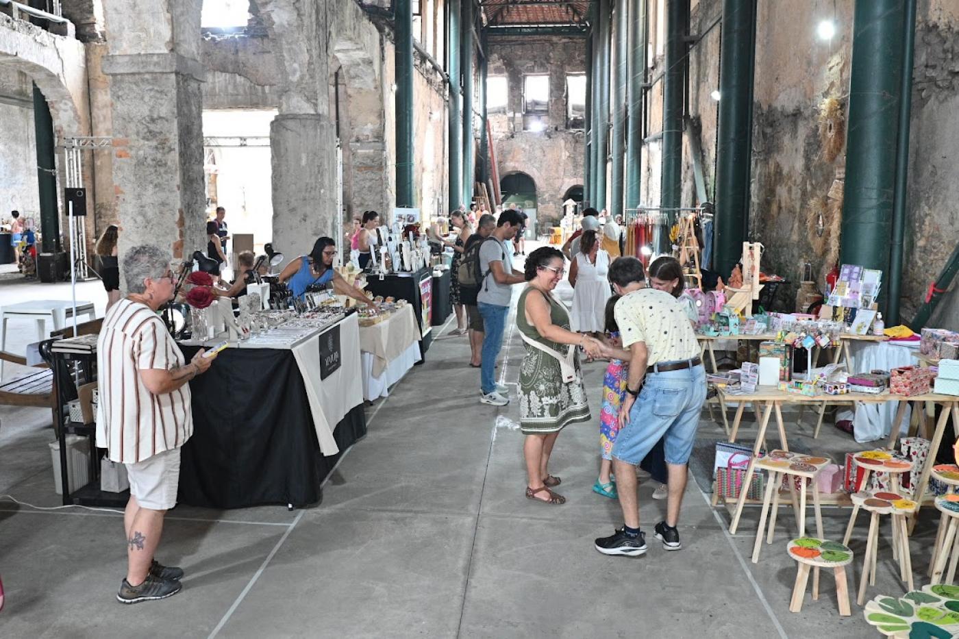 pessoas olhando produtos em feira #paratodosverem