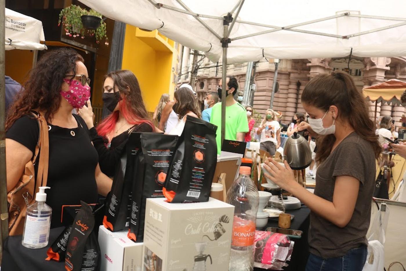 Mulher é servida em tenda de café no bulevar da XV de Novembro. #pracegover