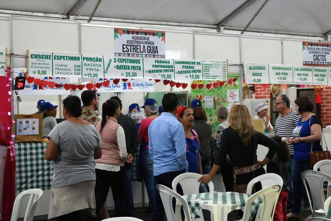 barracas de lanches e salão de refeições com pessoas circulando. #paratodosverem 