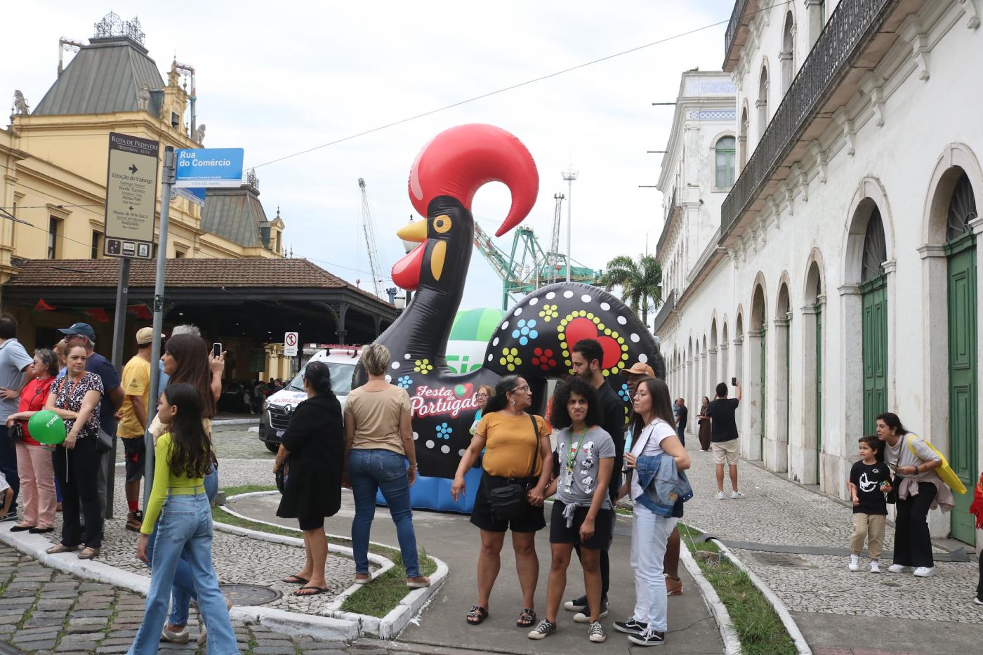 grande galo português ao fundo com turistas em torno. #paratodosverem