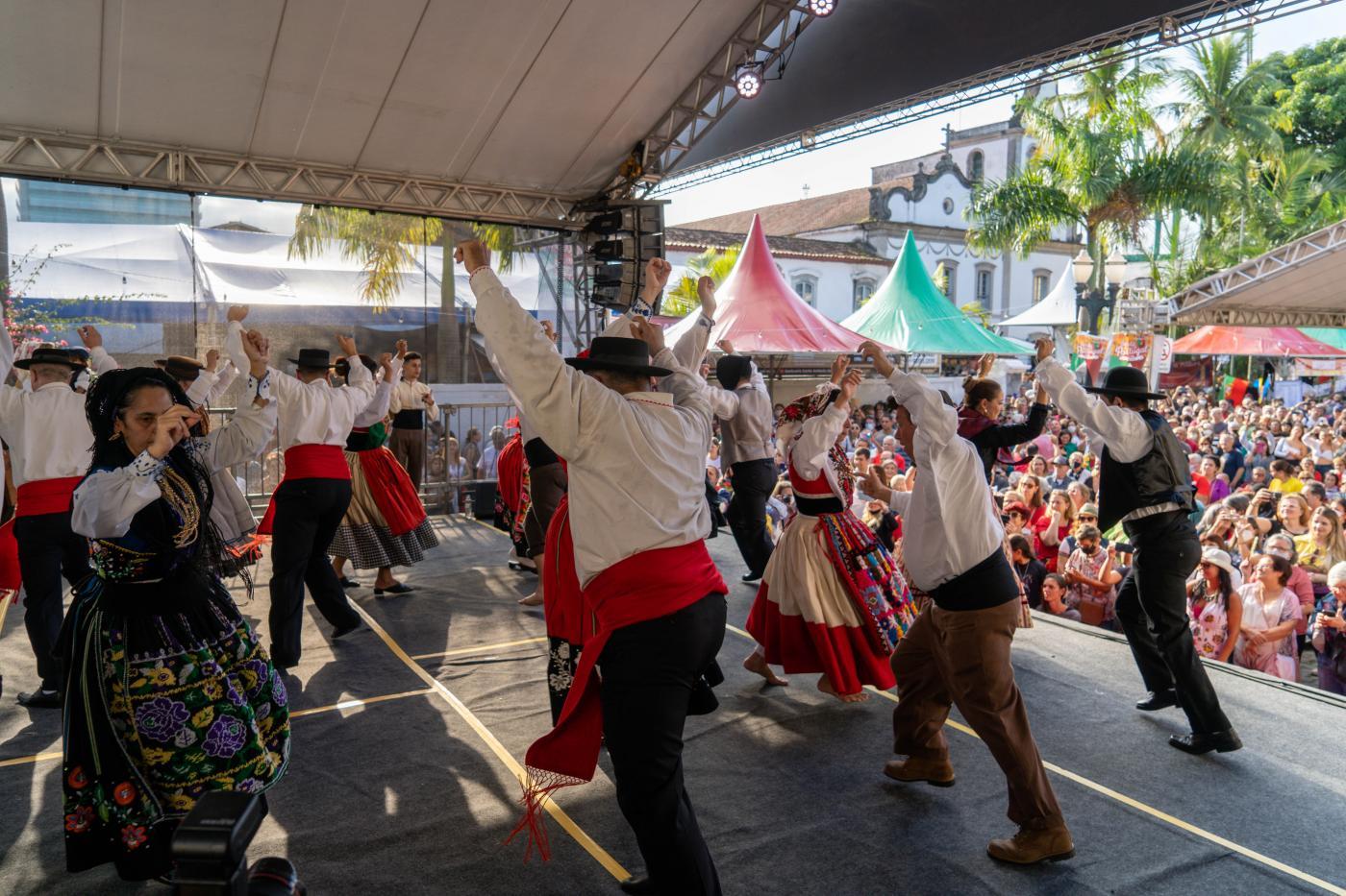 pessoas dançando com roupas típicas em palco #paratodosverem