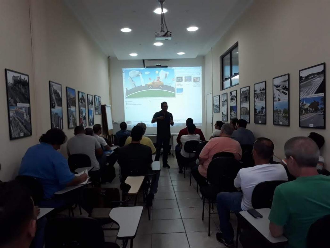 Alunos assistem ao curso com imagem em telão #paratodosverem 