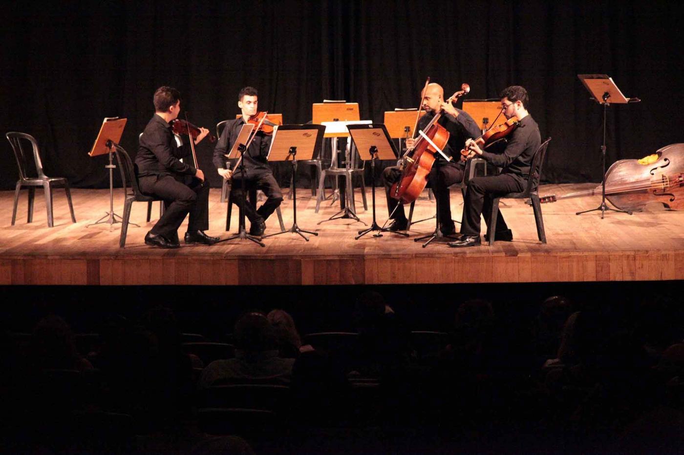 grupo toca música clássica no palco #pracegover 