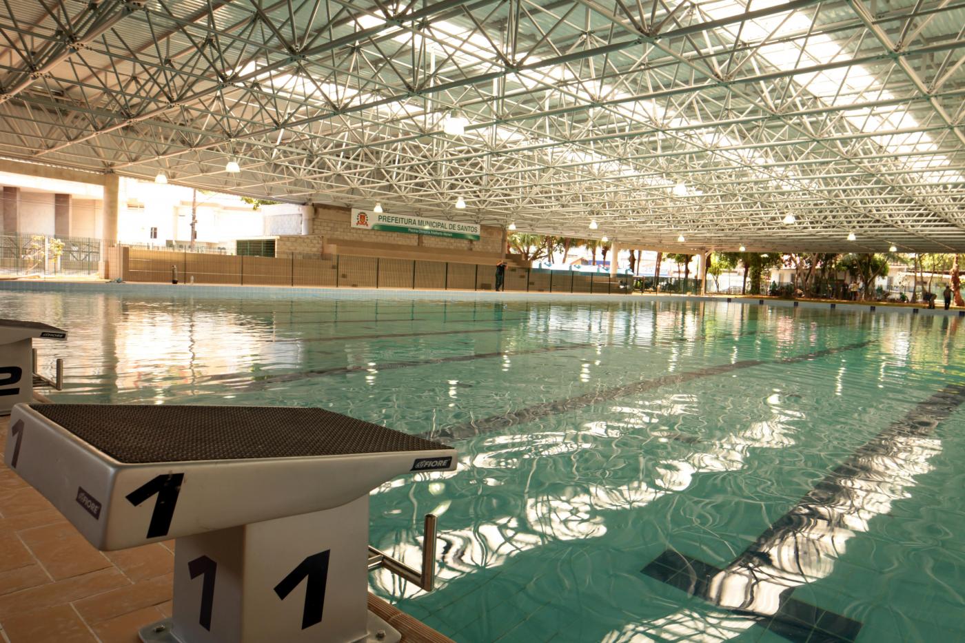 Piscina olimpica cheia d'água. Em primeiro plano os locais para salto dos atletas. #Pracegover