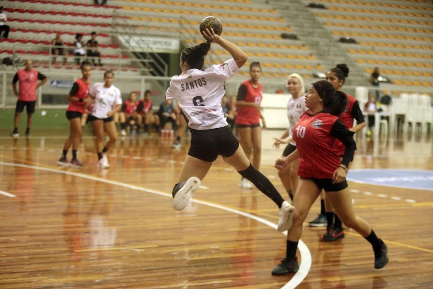 atleta de santos está lançando a bola. Seu corpo está no ar. #paratodosverem