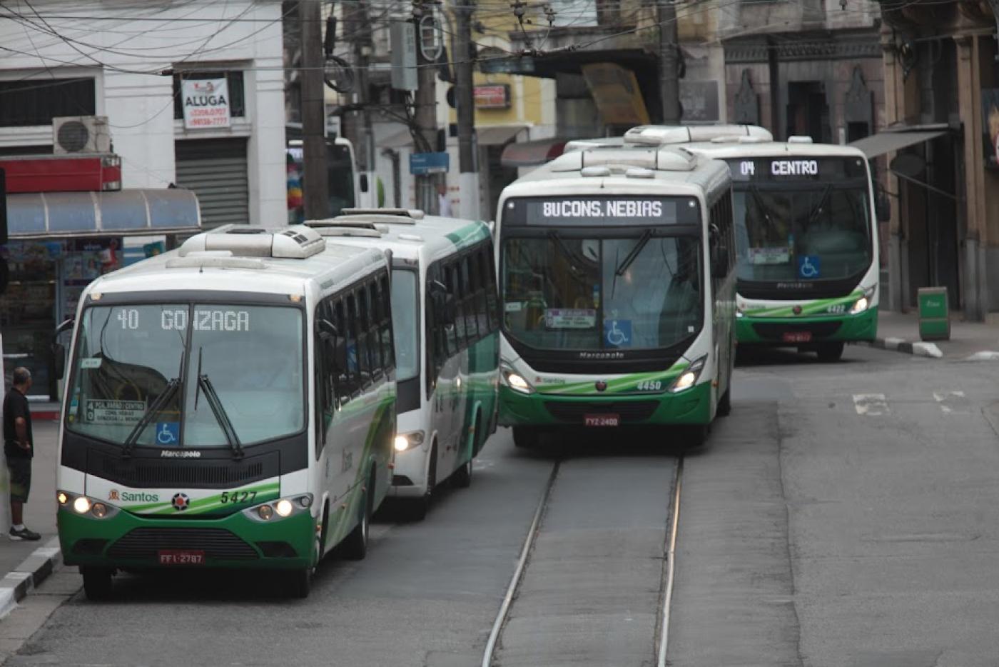 Três ônibus em uma rua. #paratodosverem