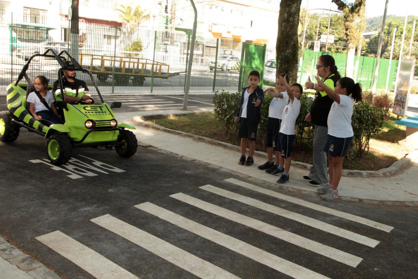 crianças fazem sinal de trânsito na Minicidade. #paratodosverem