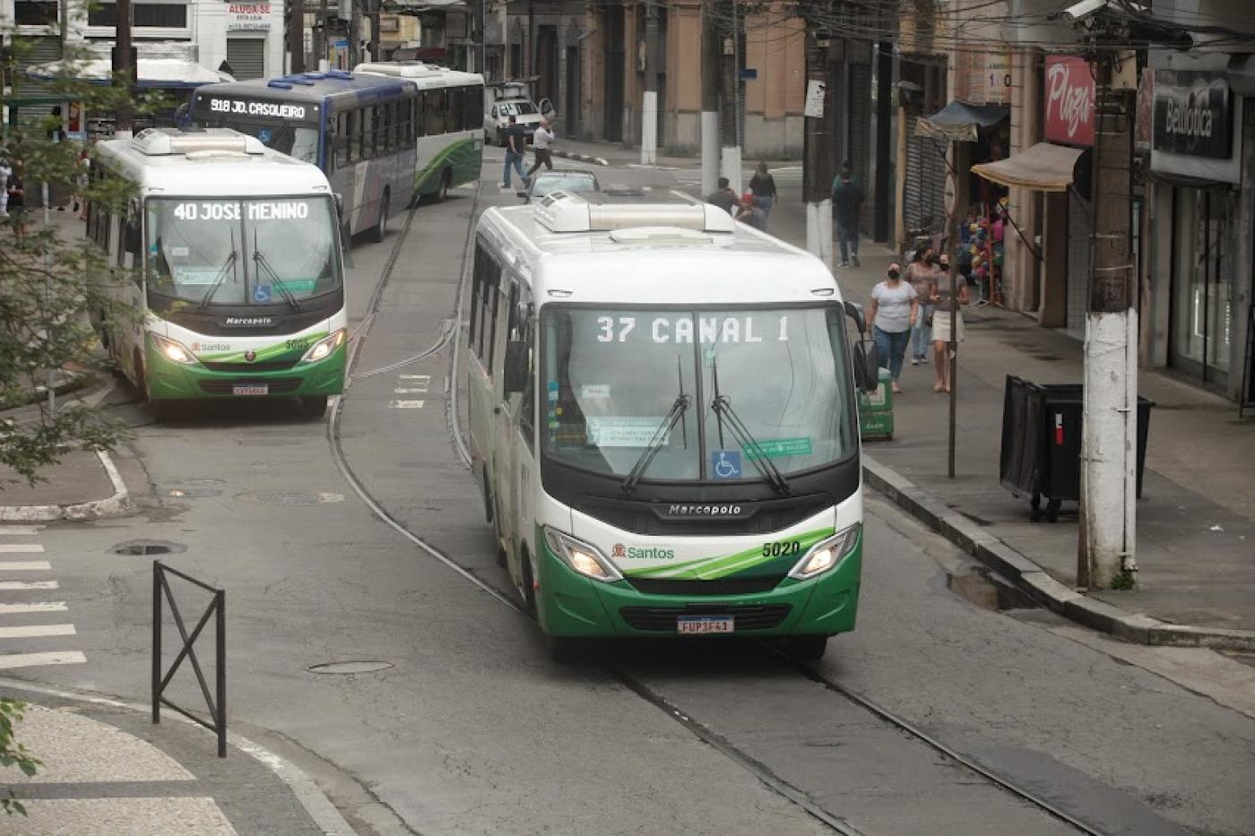 rua com quatro ônibus transitando. #paratodosverem