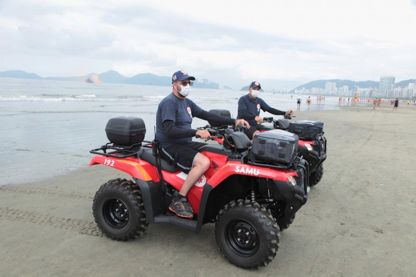 dois quadriciclos e os respectivos socorristas na faixa de área próximo ao mar. #paratodosverem