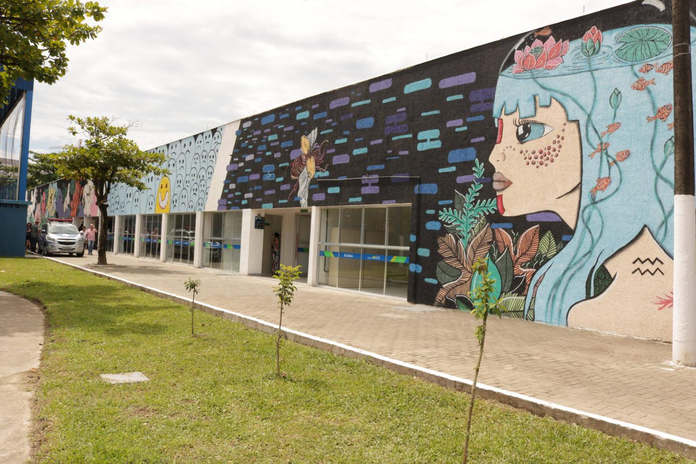 edificação com muro pintado , à frente grama #paratodosverem