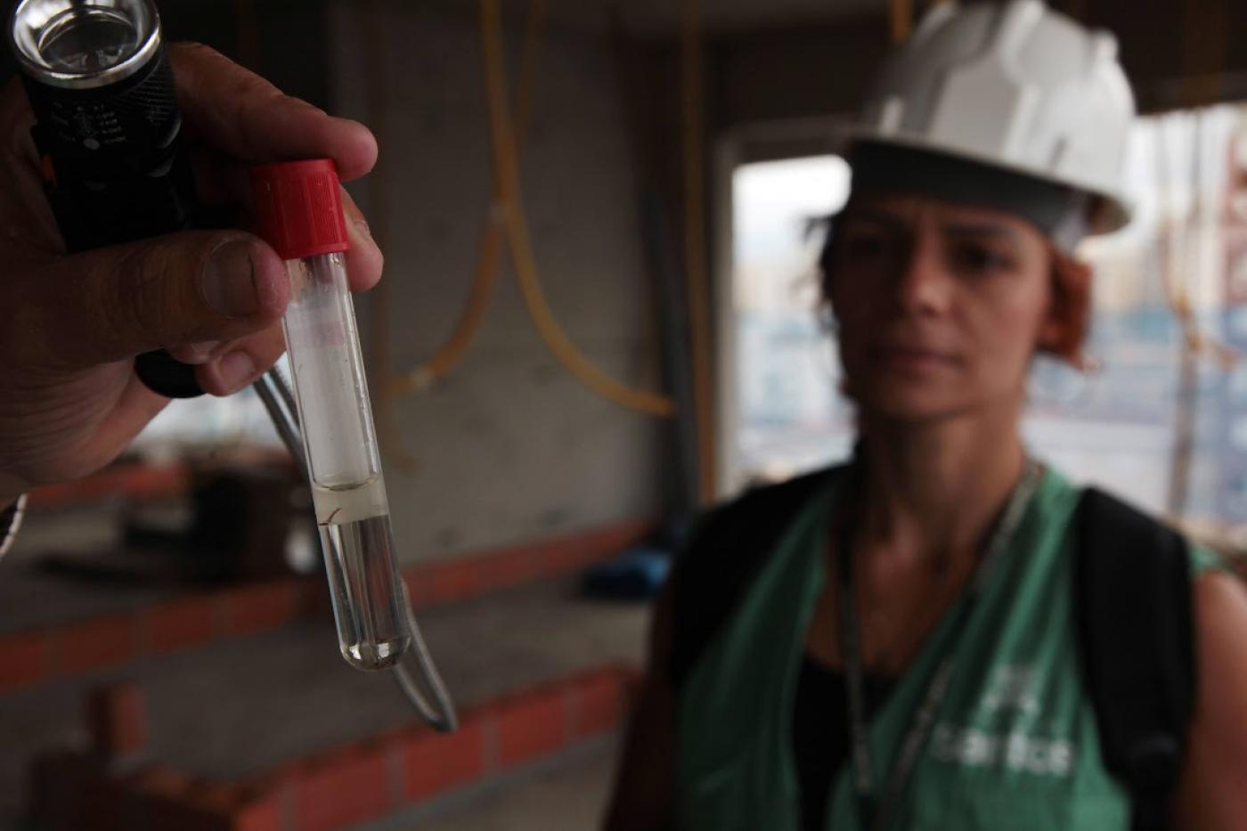 agente analisa foco em tubo de ensaio #paratodosverem 