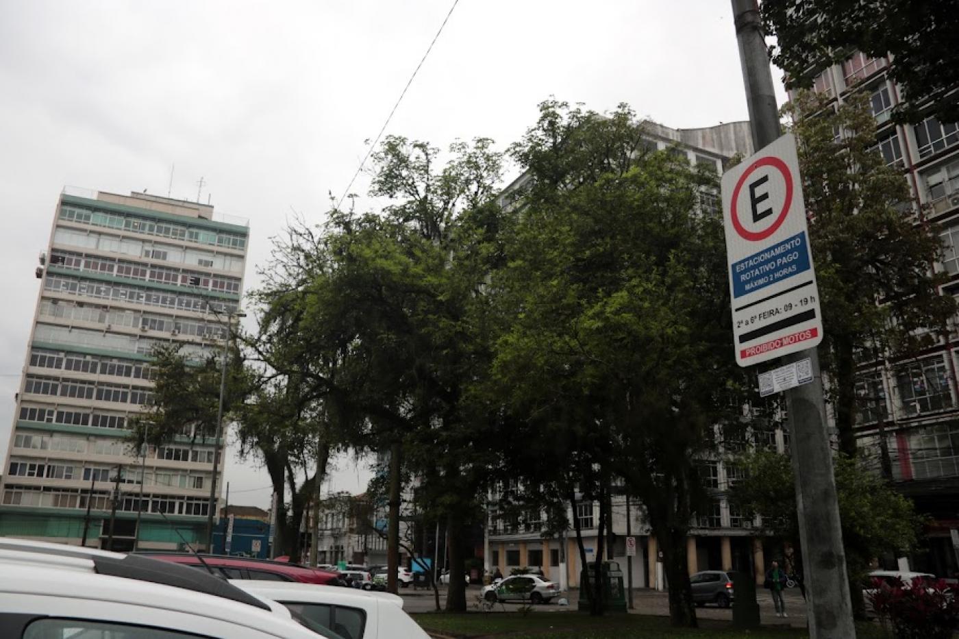placa de zona azul em posto. há carros na rua. Ao fundo se vê árvores e prédios. #paratodosverem 