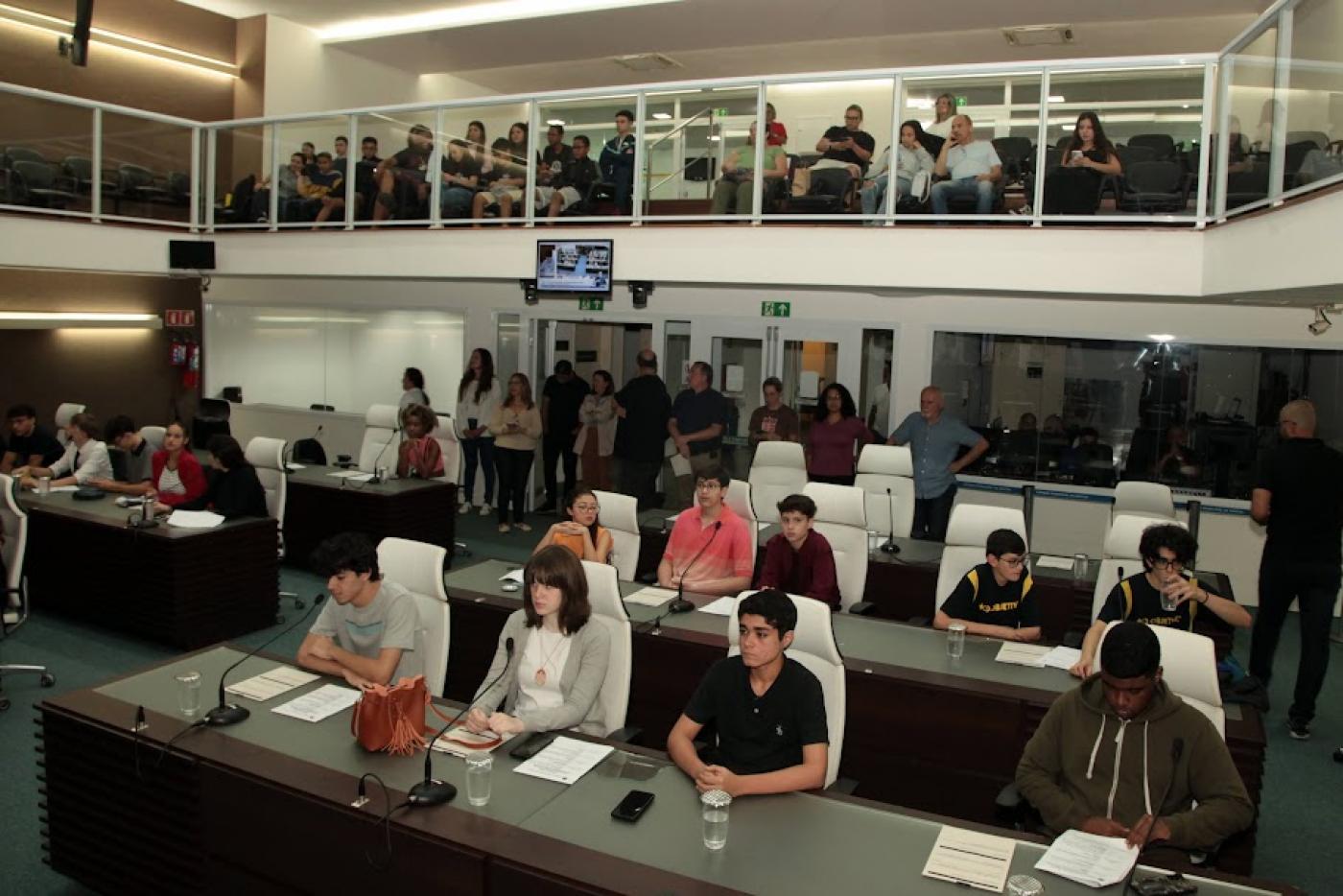 jovens estão sentados em tribuna da câmara municipal. #paratodosverem 