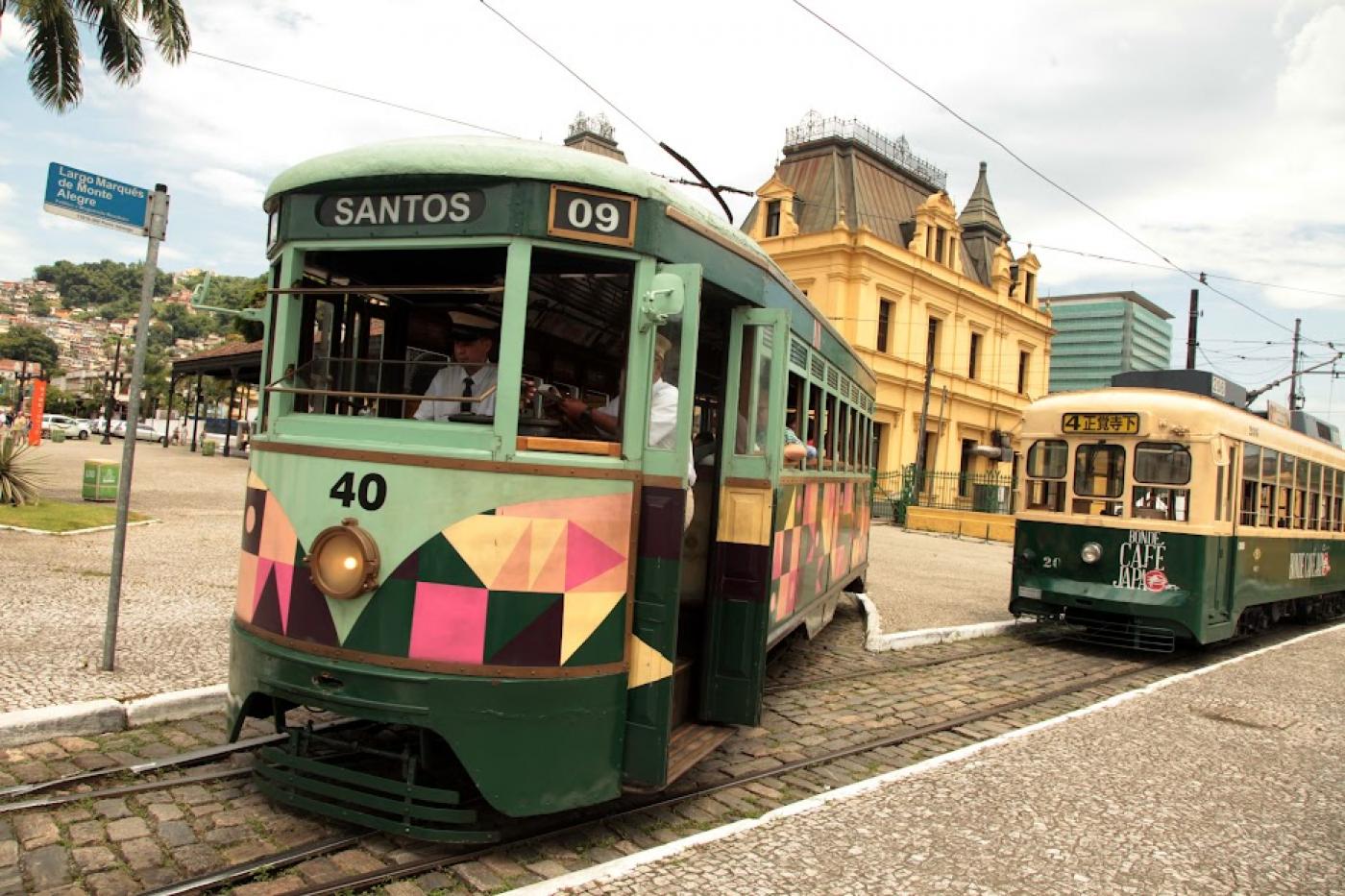 dois bondes nos trilhos em frente à estação do valongo. #paratodosverem