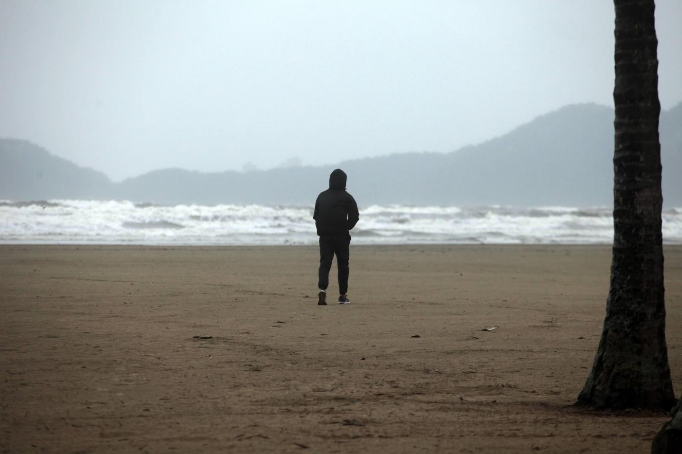 pessoa agasalhada sozinha na praia. #paratodosverem