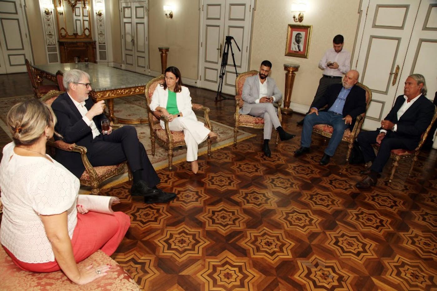 pessoas sentadas e conversando no salão nobre da prefeitura. #paratodosverem