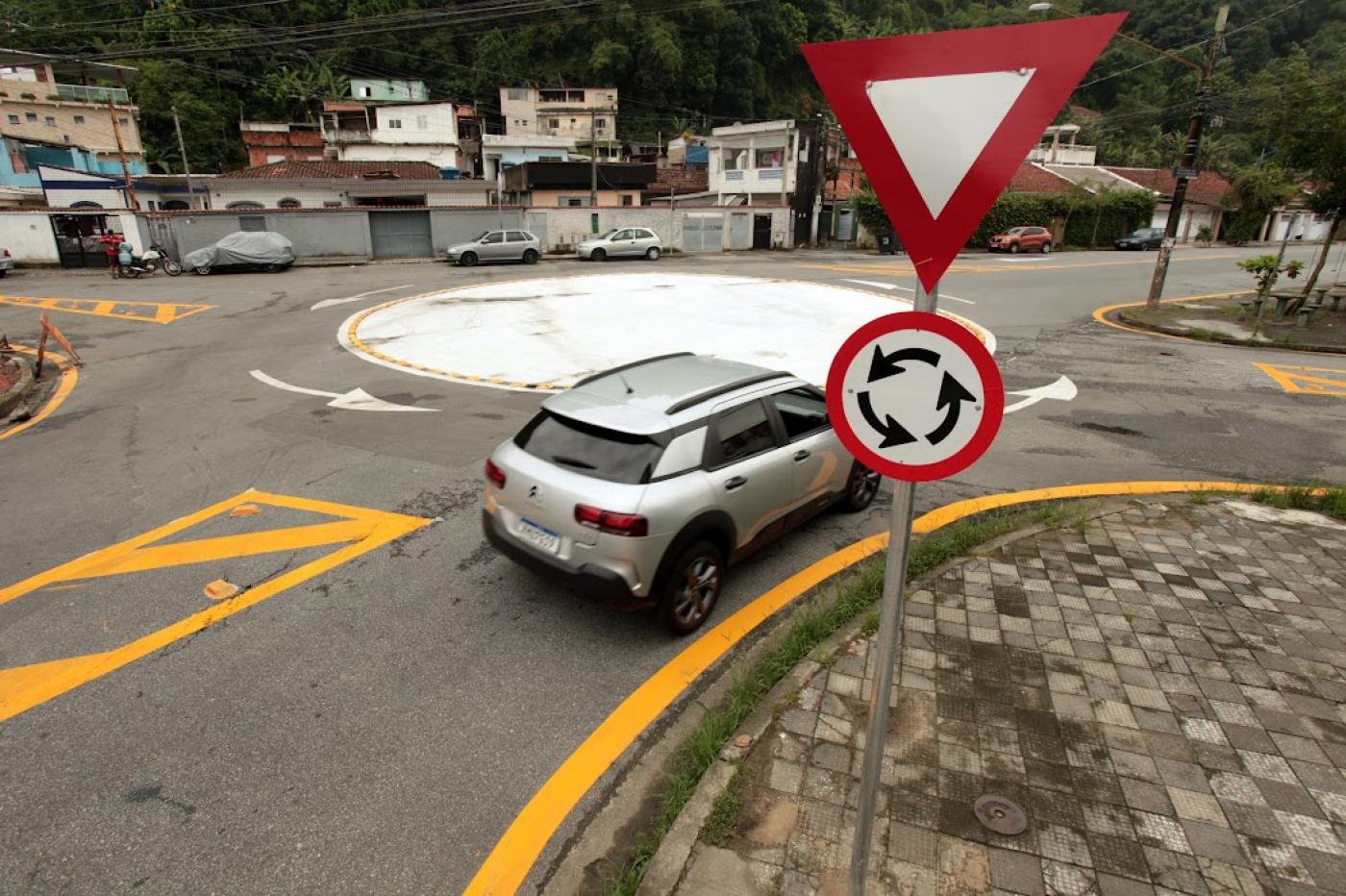 placas em primeiro plano e carro entrando na rotatória ao fundo #paratodosverem