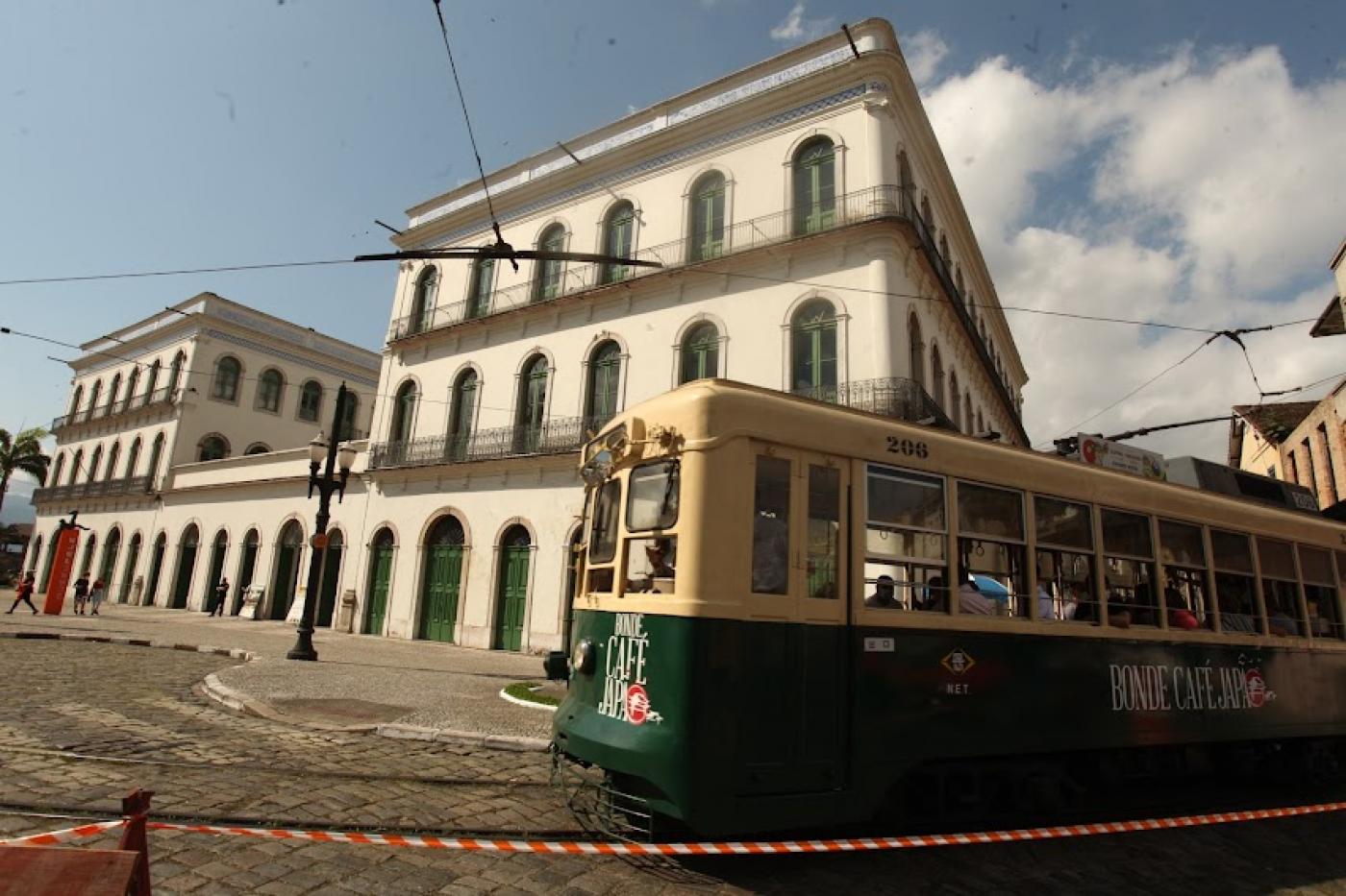 Bonde passando com museu ao fundo #paratodosverem