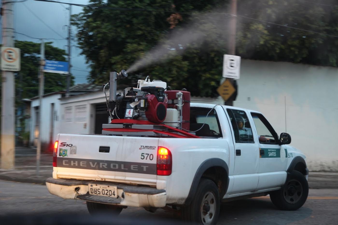 Carro dispersa fumacê pelas vias. #pracegover