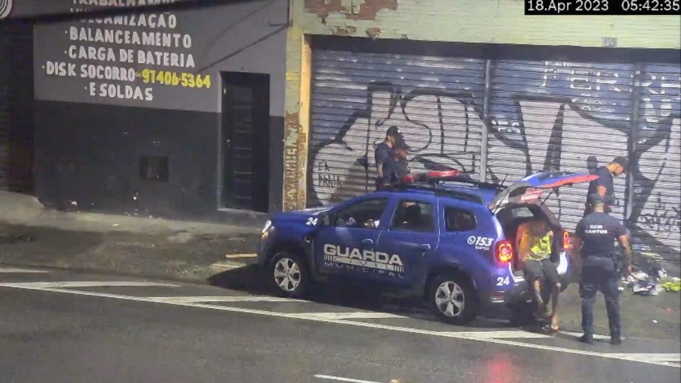 homem entra em viatura pela porta do bagageiro. #paratodosverem 