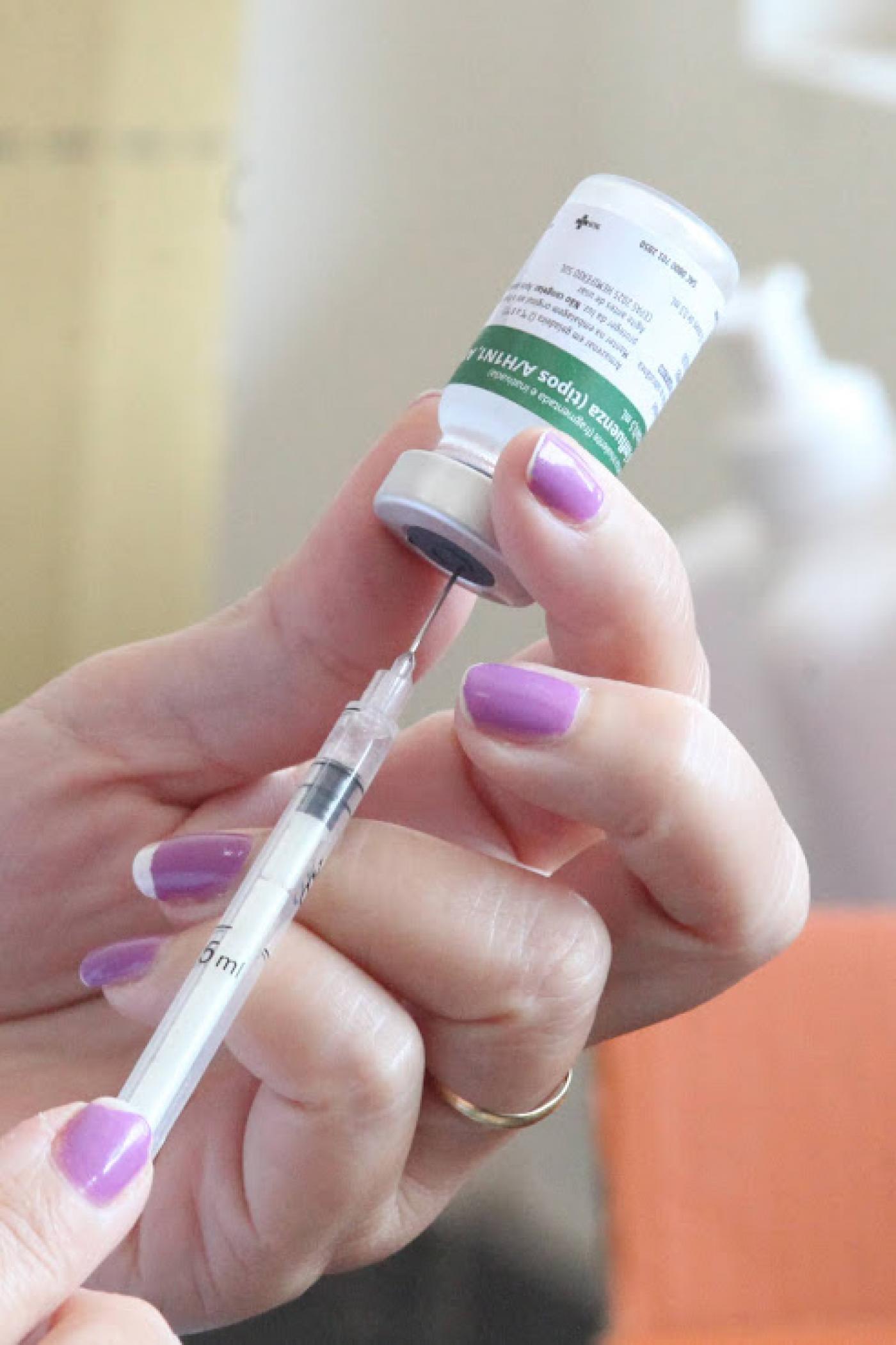 mão coleta dose da vacina em seringa #paratodosverem 