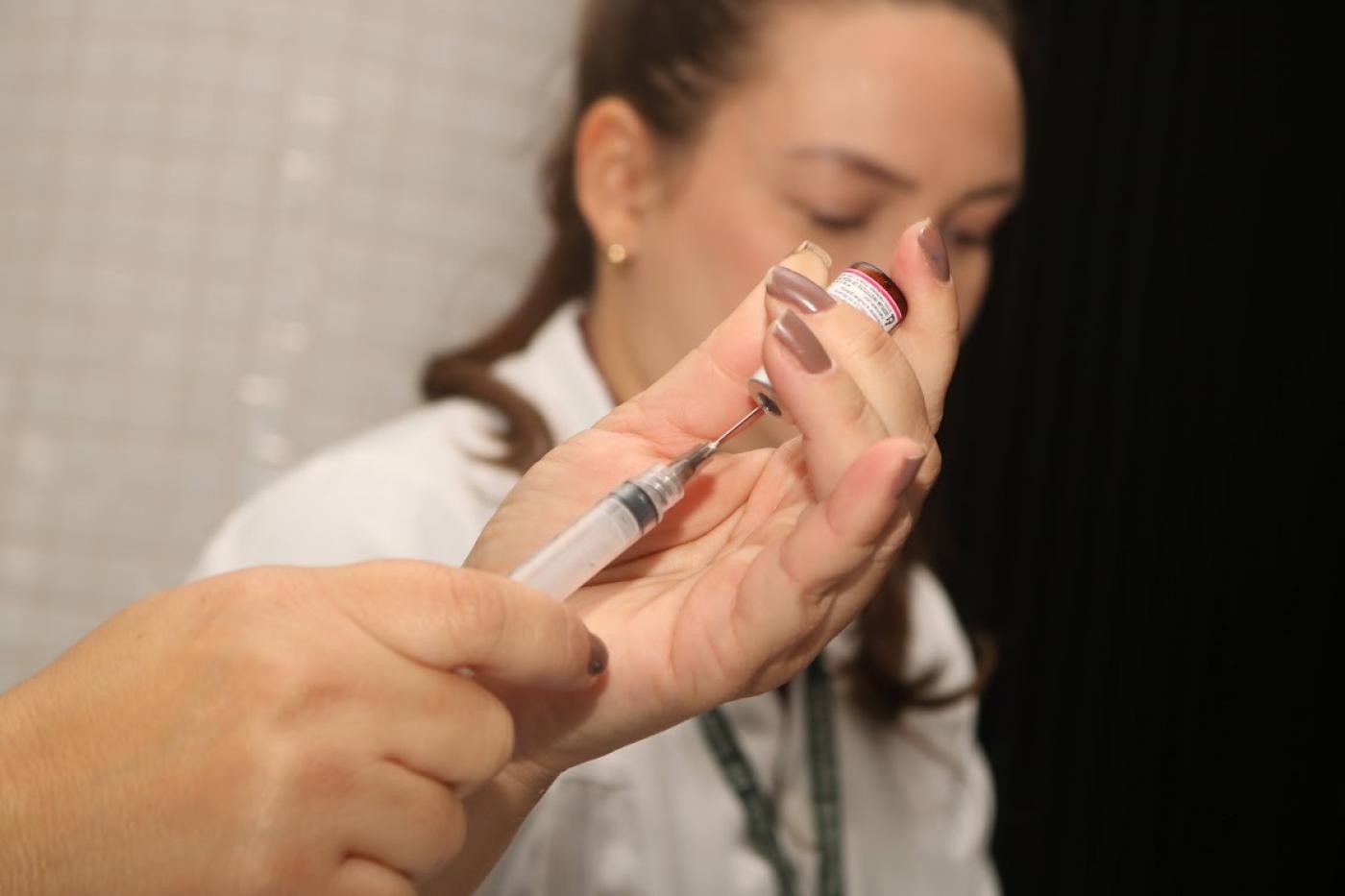 mãos preparam seringa para vacinação #paratodosverem
