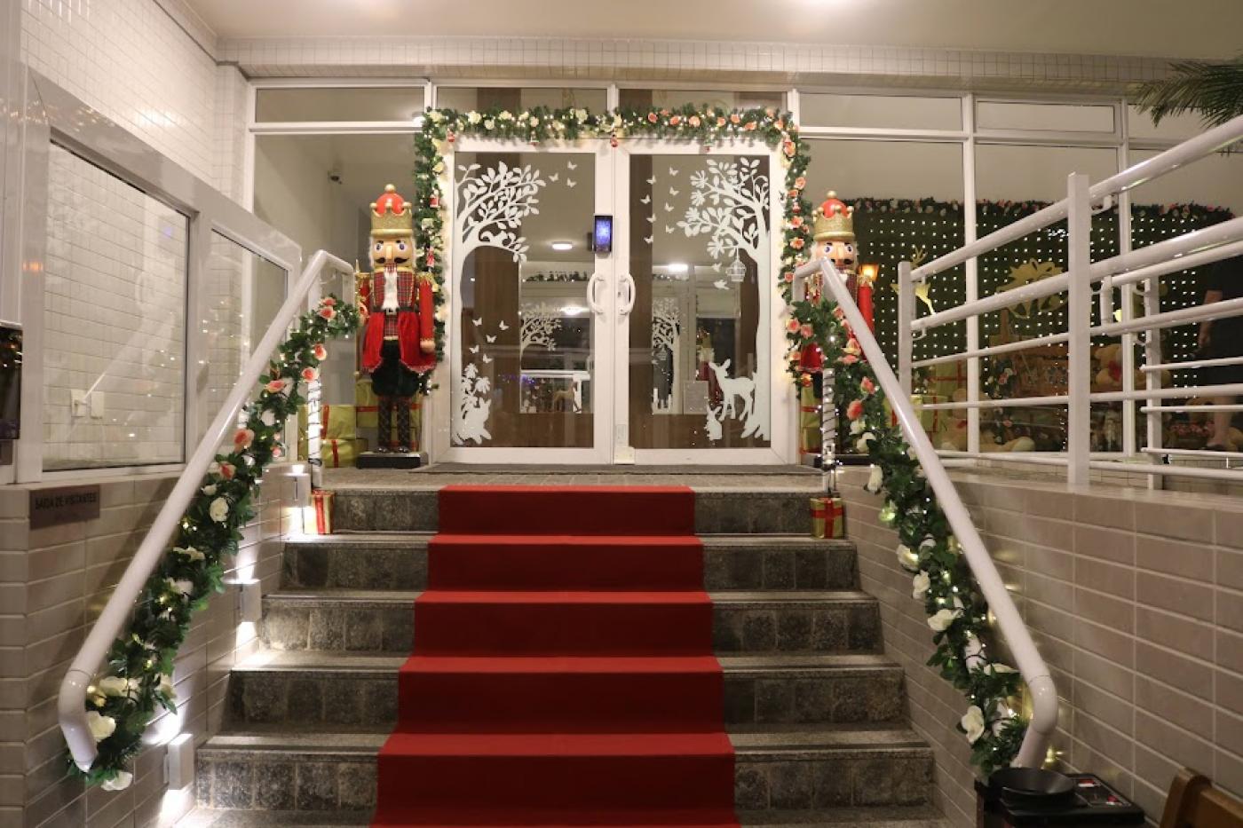 entrada de edifício decorada com festões, soldadinhos e muitas luzes. #paratodosverem