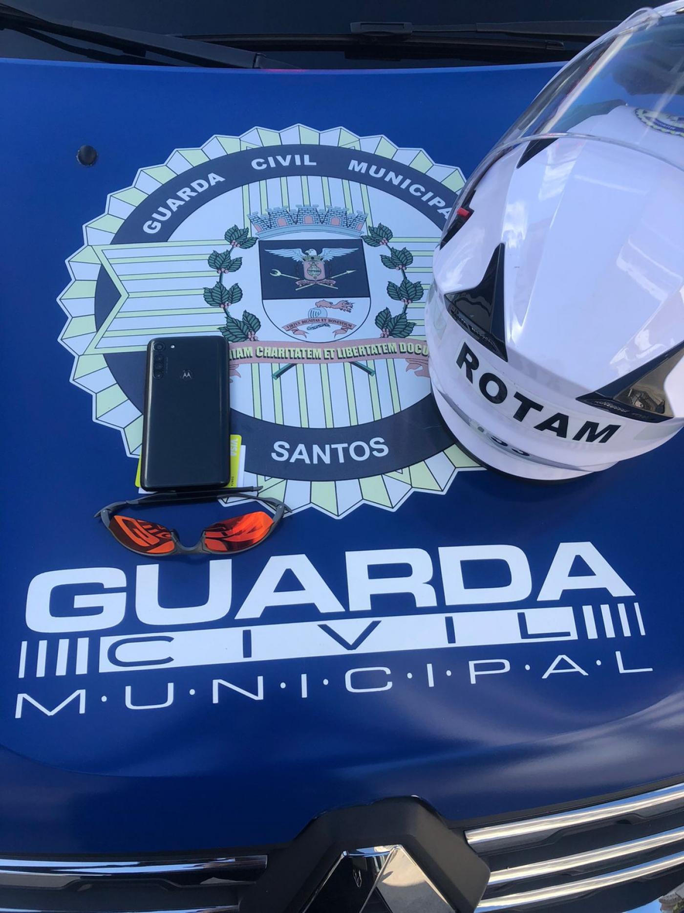 Celular e capacete sobre capô de viatura da Guarda. #paratodosverem