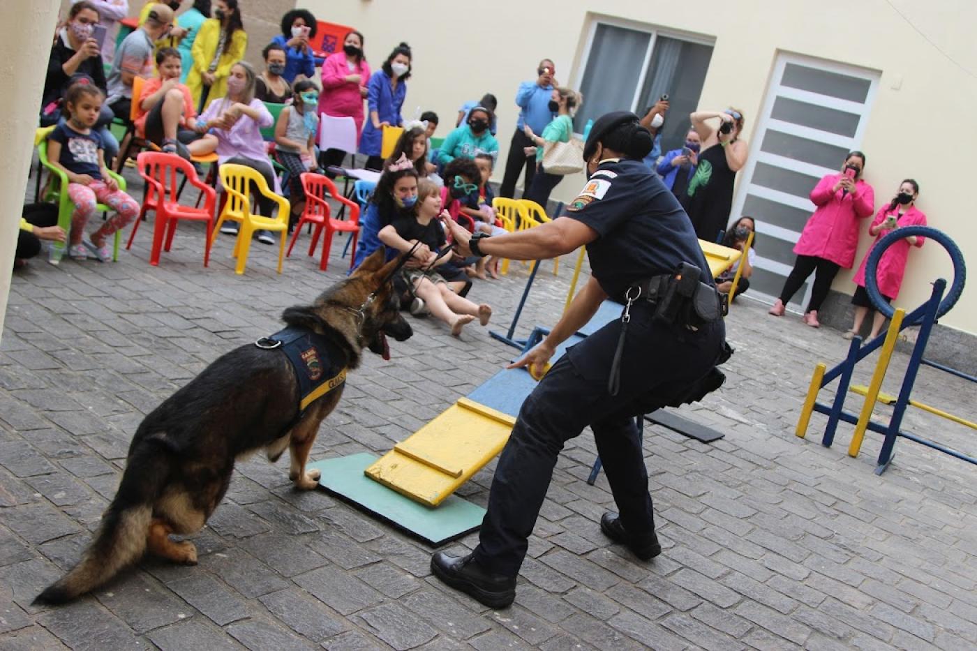 Guarda orienta cachorro em apresentação com crianças assistindo #paratodosverem