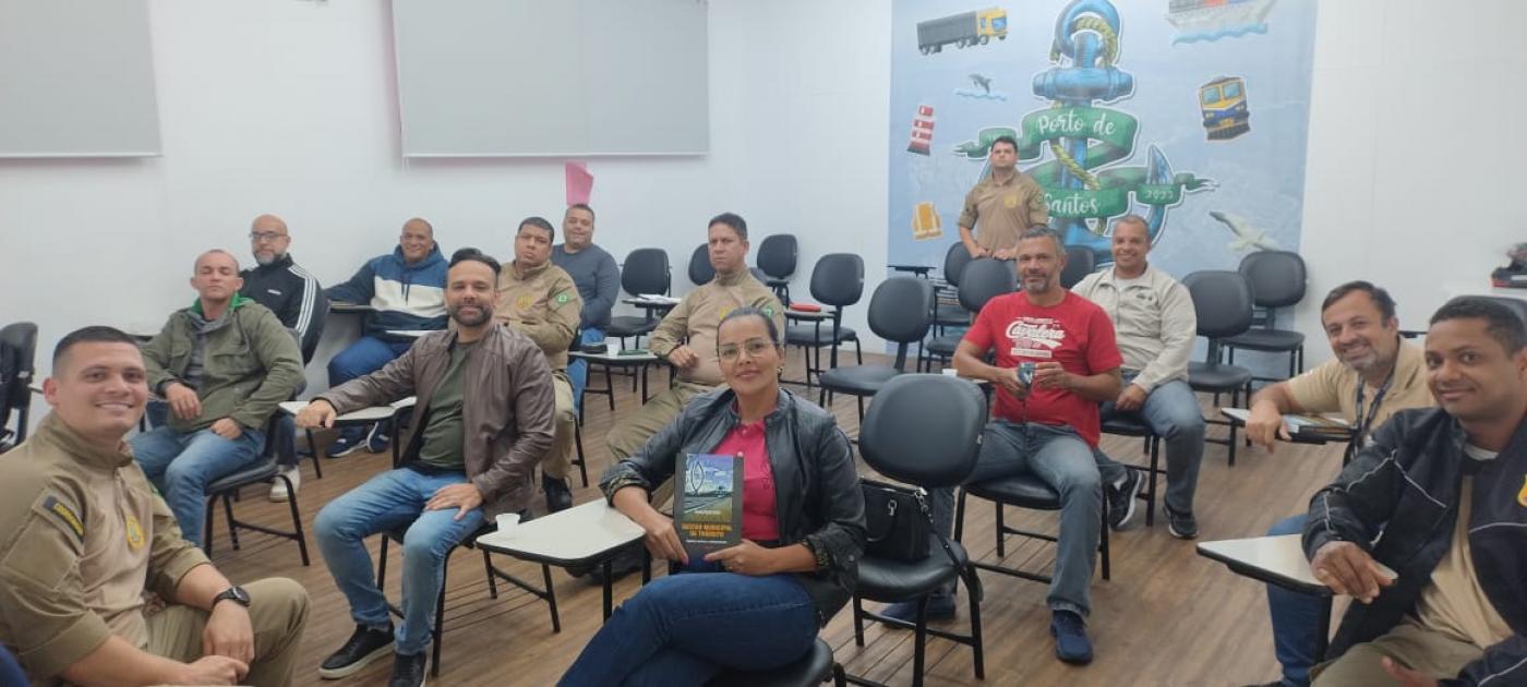 guardas portuários estão sentados em cadeiras de sala de aula. eles sorriem para a foto. #paratodosverem 