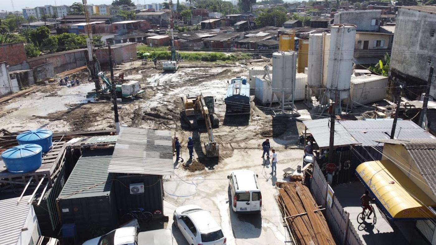 vista aérea de canteiro de obras, com perfuratrizes ao fundo à esquerda e tanques à direita. #paratodosverem