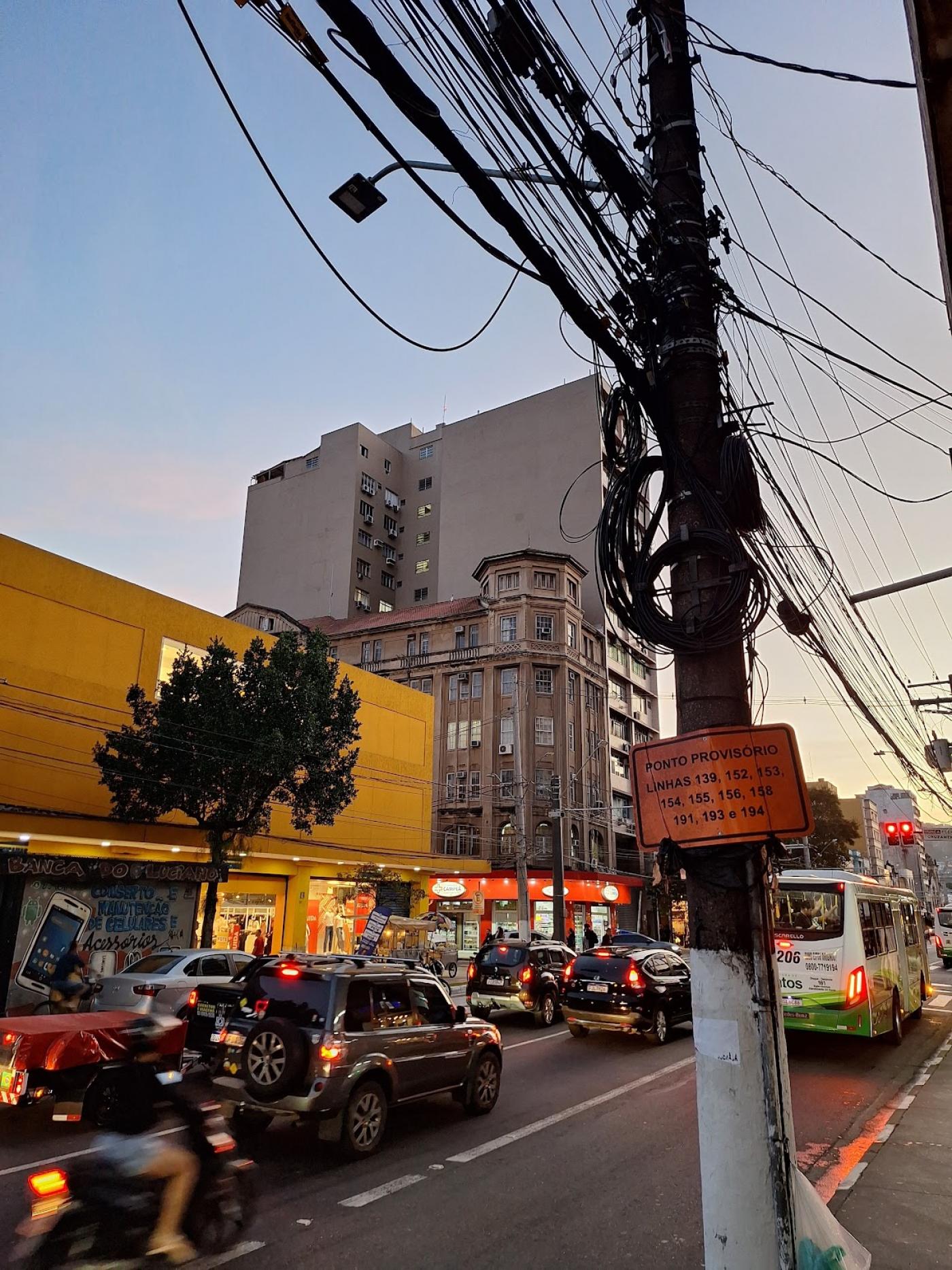 poste na rua com emaranhado de fios. #paratodosverem