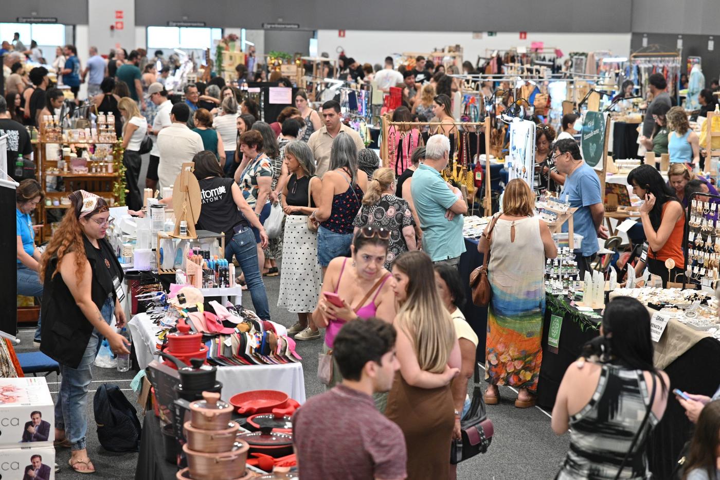 salão com expositores e grande movimento de público. #paratodosverem