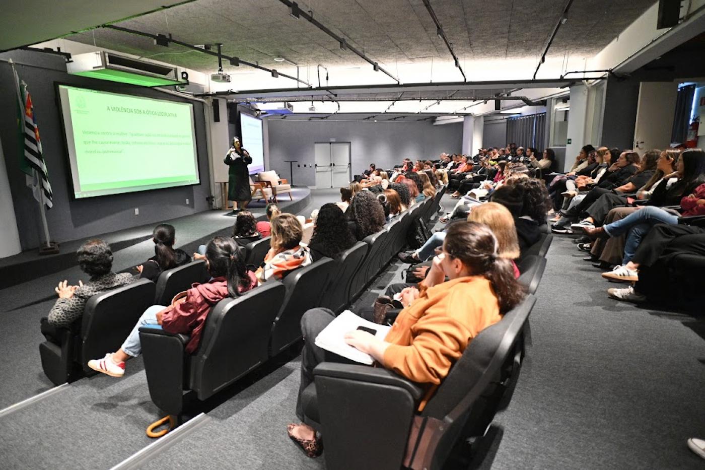 palestra com uma mulher falando para várias outras. #paratodosverem
