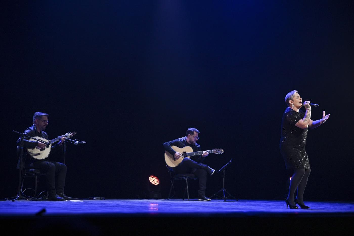 cantora e dois músicos em palco. #paratodosverem