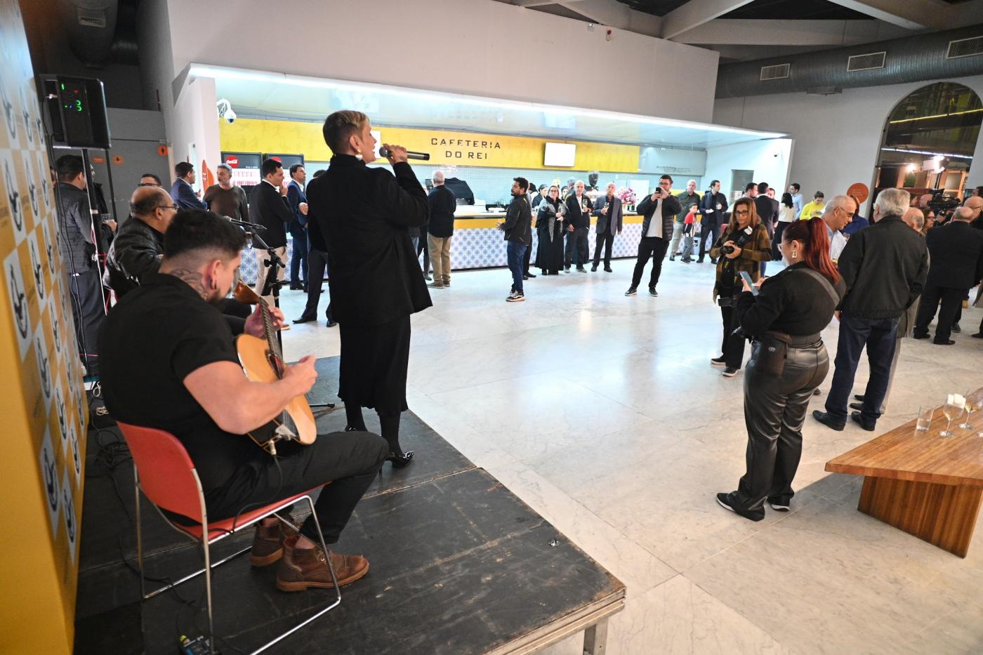 cafeteria com pessoas e apresentação musical. #paratodosverem