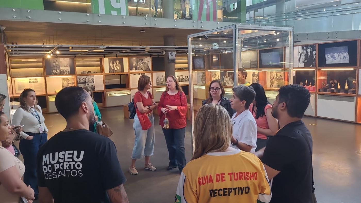 agentes turísticos atentos a orientações no Museu Pelé. #paratodosverem