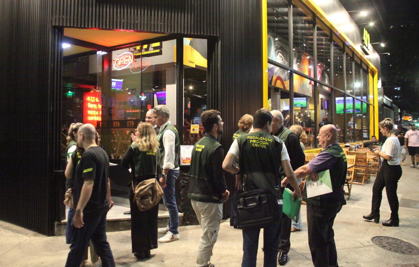 fiscais uniformizados do procon em frente a um bar. #paratodosverem