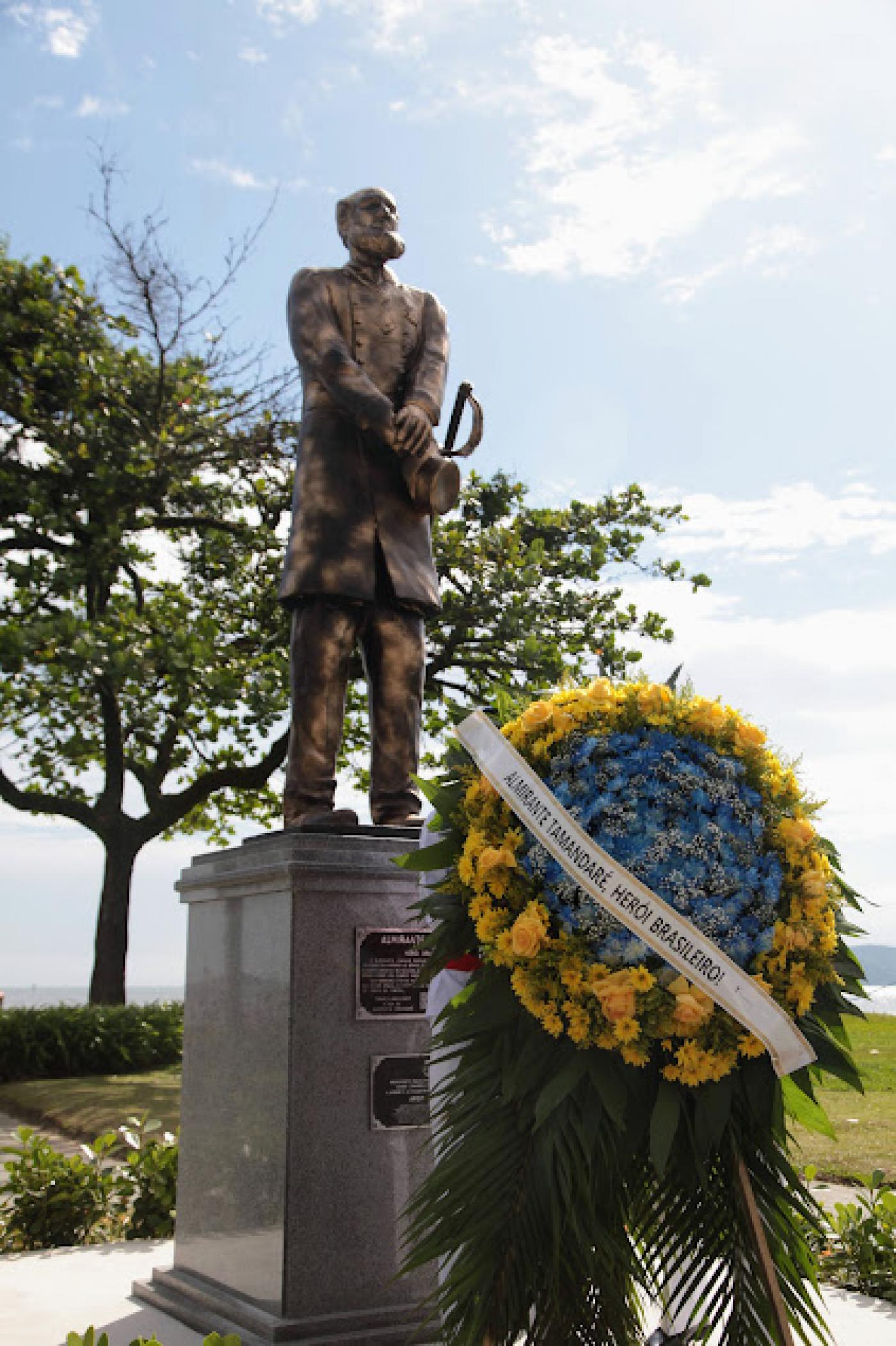 a estátua com coroa de flores à frente. #paratodosverem 